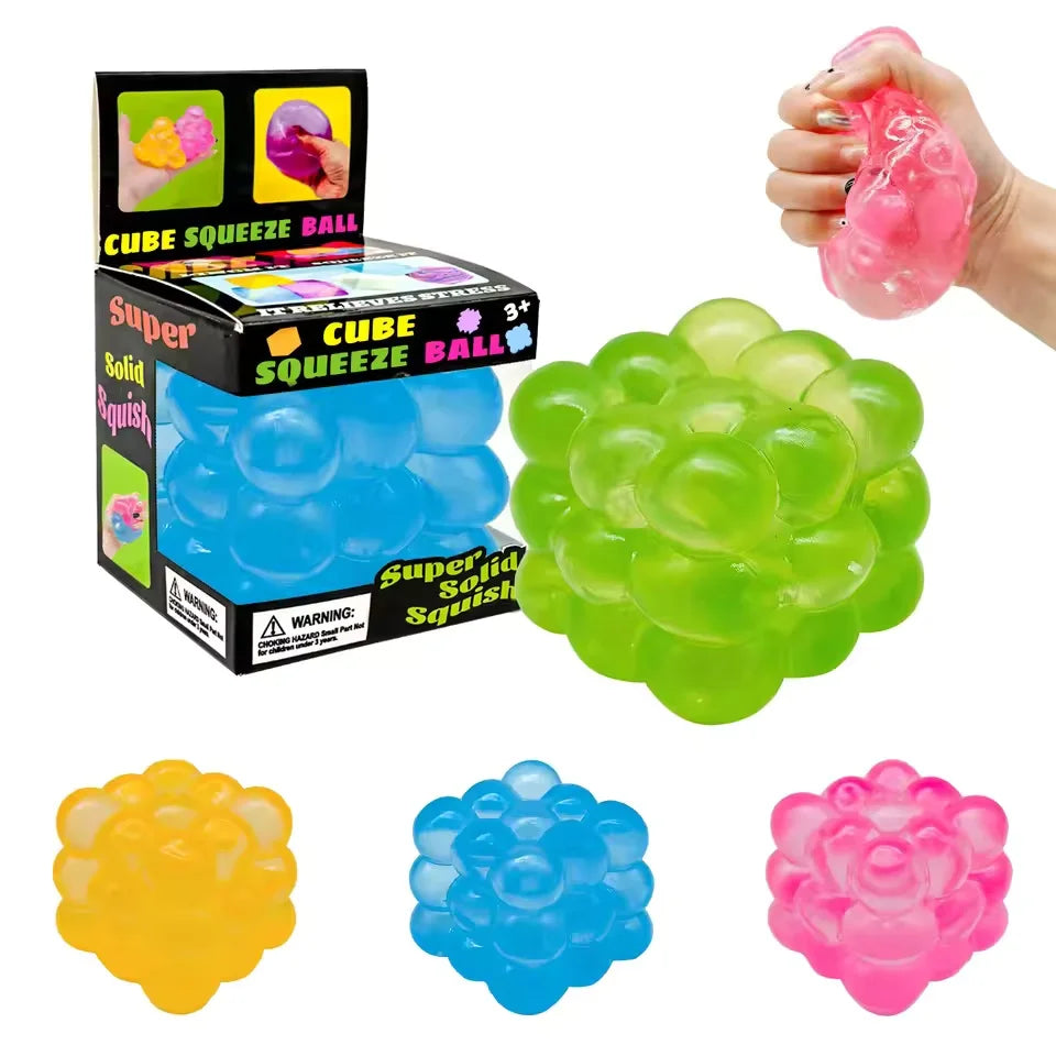 Bumpy candy cube squishies in green, yellow, blue and pink with a display box