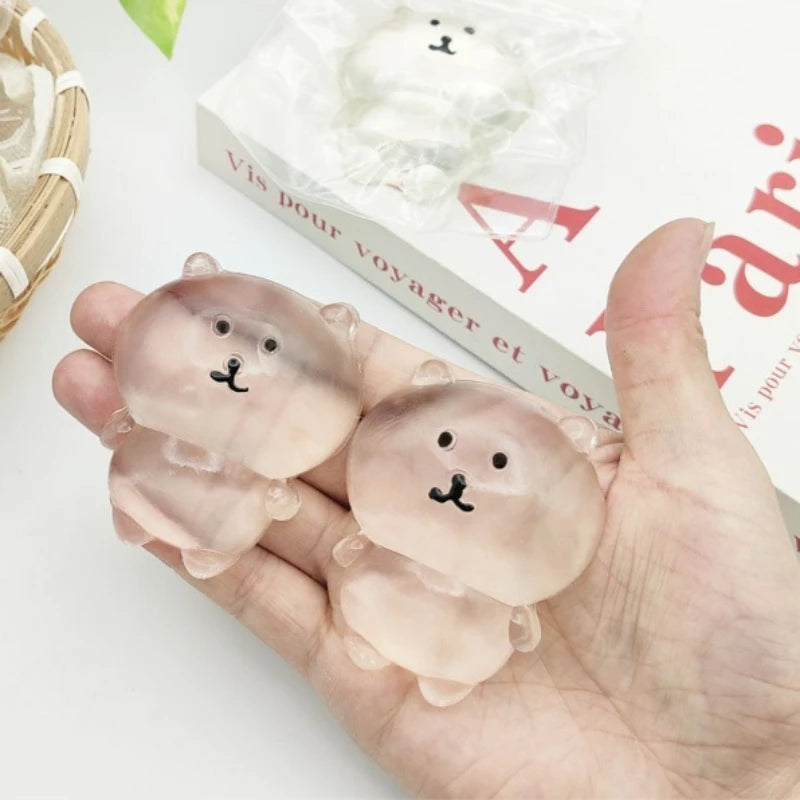 Two translucent kawaii bear squishies with printed faces resting in a hand
