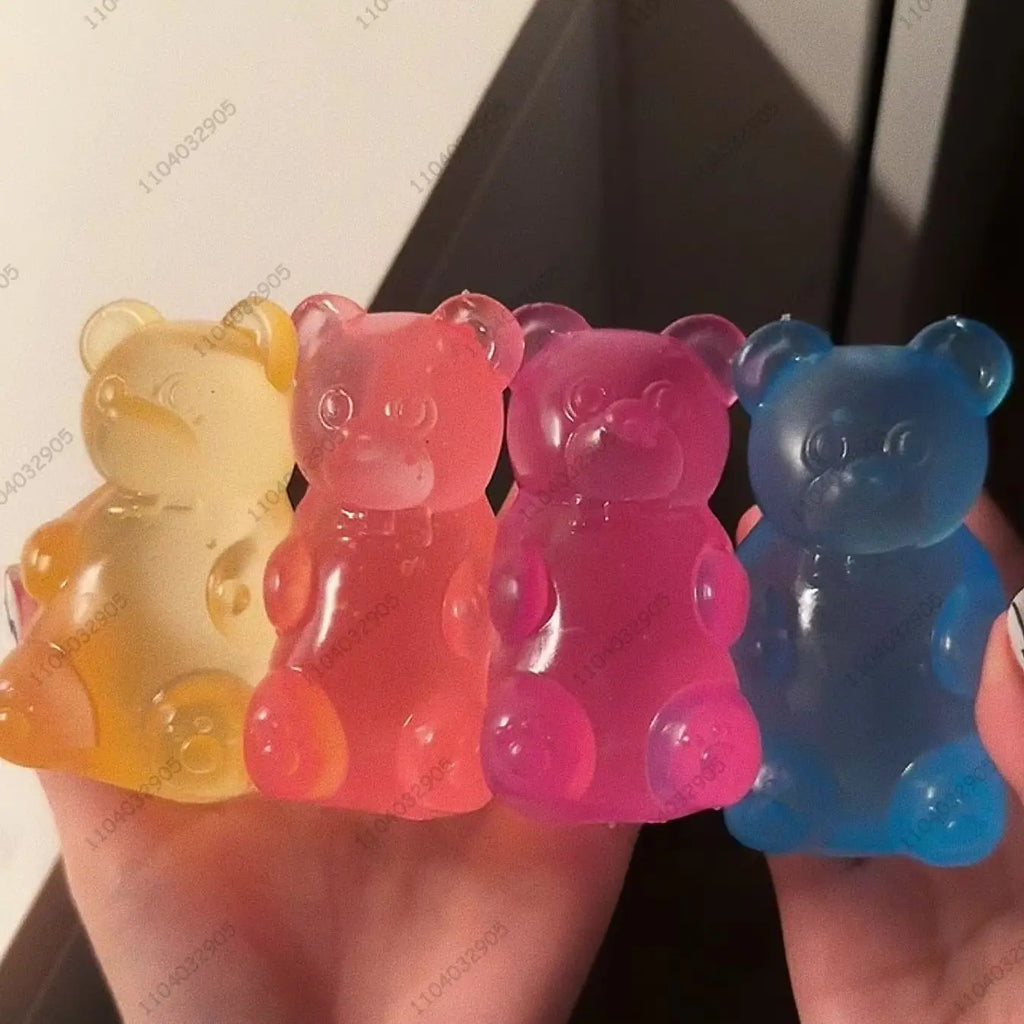 Translucent gummy bear squishies in yellow, red, blue and pink held in a hand