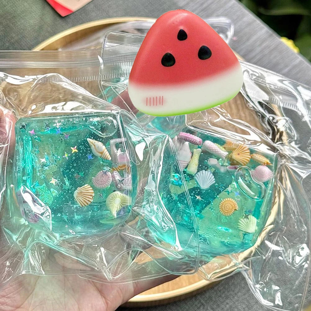 Translucent blue ocean block jelly cube squishy holding miniature shells and glitter