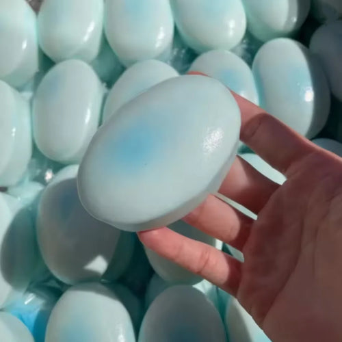 Pale blue cheese cake squishy being pressed flat in a hand
